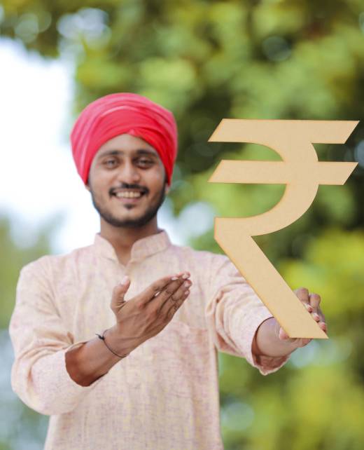 Young indian farmer holding rupees symbol in hand.